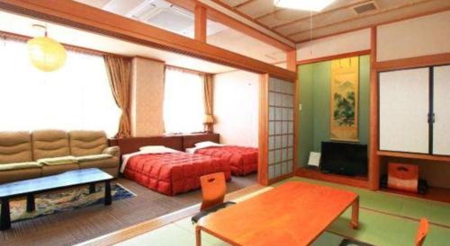 a living room with two beds and a couch at Hotel Honjin in Kumamoto