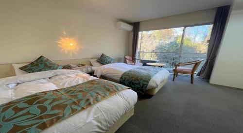 a hotel room with two beds and a window at Hotel Miyama in Chichibu