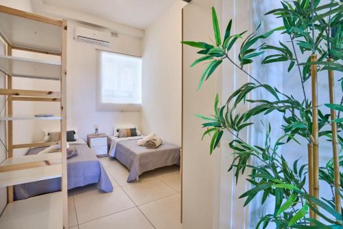a room with a bed and a plant at Seaview Balluta-StJulians-Prime Spot in St Julian's