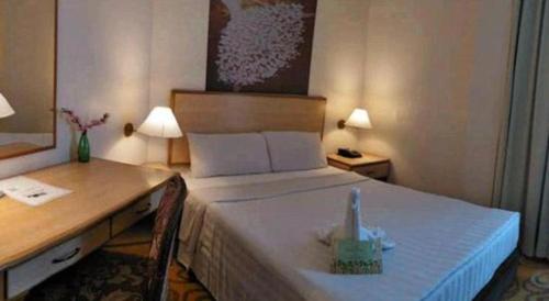 a hotel room with a bed and a desk and a bed sidx sidx sidx sidx at The Orchid Hotel in Sibu
