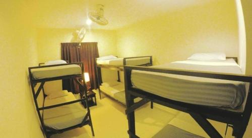 a room with two bunk beds and a desk at Perhentian Tivoli Inn in Perhentian Island