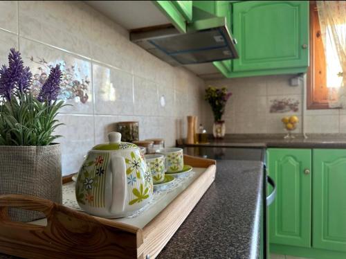 a kitchen with green cabinets and a counter with vases on it at Eleocharis near Amfilochia & Amvrakikos Gulf in Amfilochía