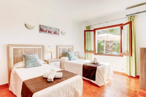 sypialnia z dwoma łóżkami i oknem w obiekcie Villa Antonia Sol by Villa Plus w mieście Cacla D'or