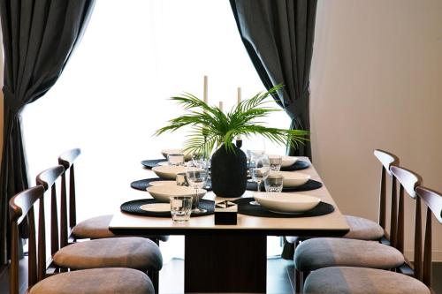 een eettafel met stoelen en een groot raam bij JUNGLIA House in Biimata