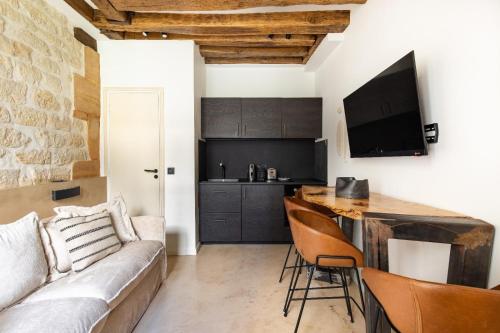 une cuisine et un salon avec un canapé et une table dans l'établissement Authentic apartment - 1BR-4P - Le Marais, à Paris