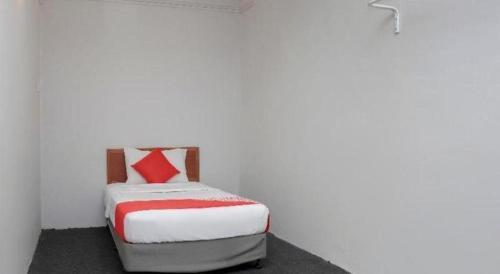 a bedroom with a bed with a red and white blanket at OYO 90120 MI Hotel Dungun in Dungun