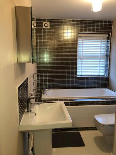 a bathroom with a sink and a tub and a toilet at Cozy Sheffield Guest Room with Shared Facilities in Sheffield