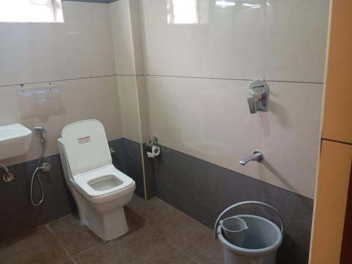 a bathroom with a toilet and a sink at Hotel Rotano Garden Near Marathahalli Bridge in Bengaluru