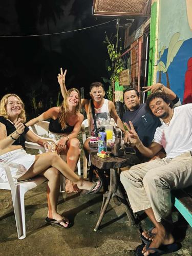 a group of people sitting around a table at mama hostel Bed & Breakfast in El Nido