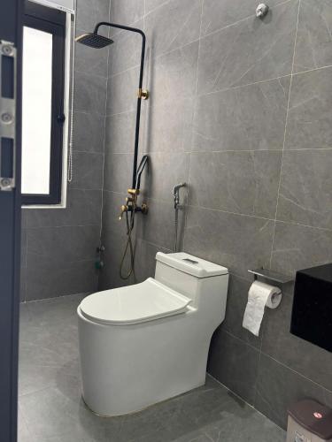 a bathroom with a white toilet and a shower at Sunrise Homestay in Danang