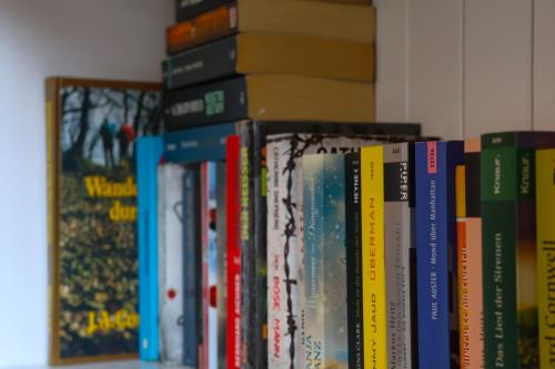 a row of books on a shelf at Hotel an der Therme in Bad Dürkheim