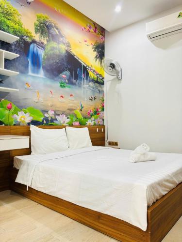 a bedroom with a large painting on the wall at Sunrise Homestay in Danang