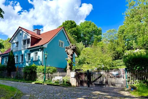 a blue house with a fence on a street at Landhaus am See Flecken Zechlin in Rheinsberg