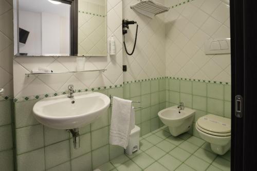 a white bathroom with a sink and a toilet at Hotel Ristorante Da Tonino in Recanati
