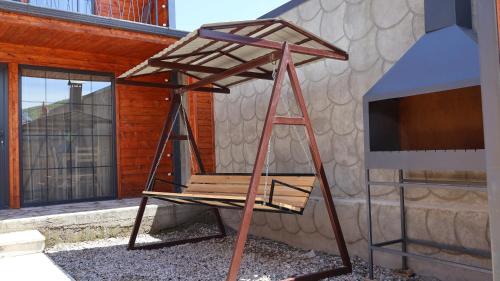 a wooden chair sitting in front of a building at The village Rest House in Aghk'ilisa