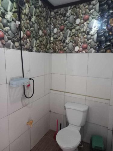 a bathroom with a toilet and a shower in it at mama hostel Bed & Breakfast in El Nido