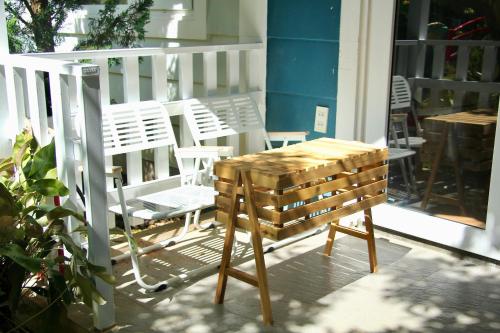 a wooden table and chairs on a porch at Homestay Đà Lạt - The November Stay in Da Thanh
