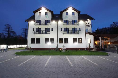a large white building with a parking lot at night at Amso Residence in Sibiu