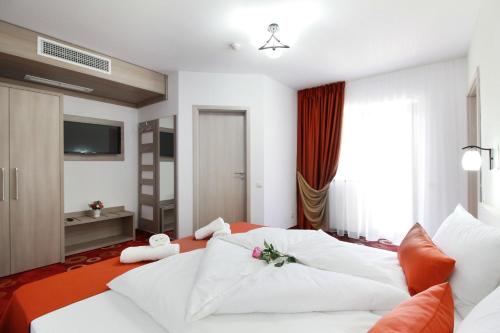 a hotel room with a white bed and a television at Amso Residence in Sibiu
