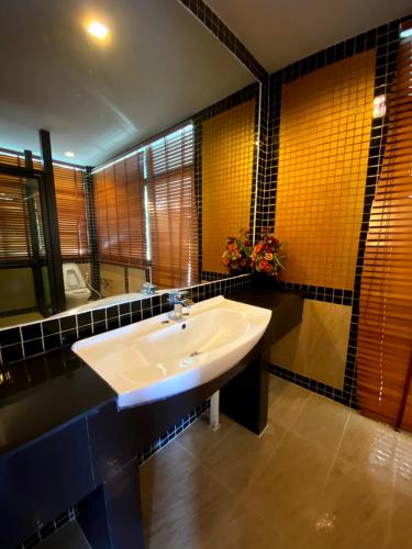 a bathroom with a sink and a large mirror at The Belmont Khao Yai Private Mansion in Pak Chong