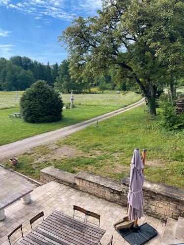 a woman in a robe standing next to a bench at Gîte de l'Abbaye de l'Étanche in Rollainville