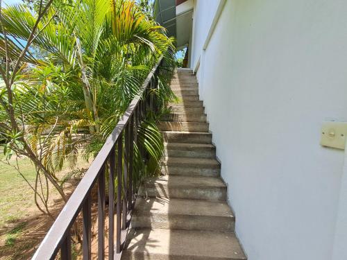 a stairway leading up to a house with palm trees at Holiday Beach Guesthouse in Kalkudah