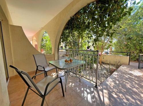 a patio with a table and chairs on a balcony at Beach Town House, Green Garden, 2 bedrooms, 2 bathrooms in Paphos