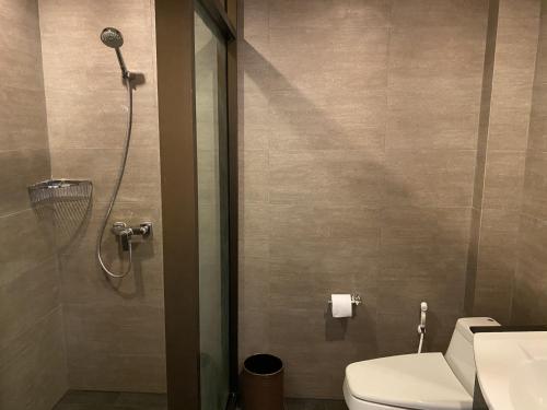 a bathroom with a shower with a toilet and a sink at The Belmont Khao Yai Private Mansion in Pak Chong