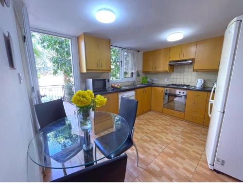 a kitchen with a glass table with a vase of flowers on it at Beach Town House, Green Garden, 2 bedrooms, 2 bathrooms in Paphos