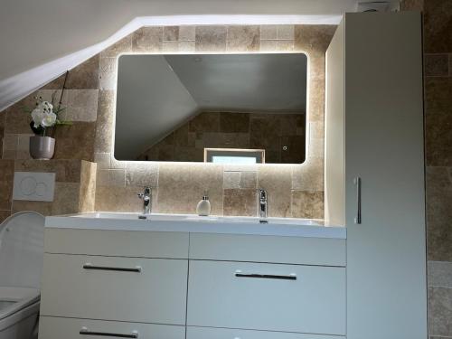 a bathroom with a white sink and a mirror at 5-room house in Orgeval