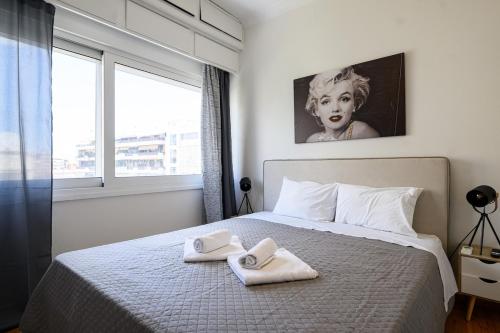 a bedroom with a bed with two towels on it at Patision cinema apartment in Mesochórion
