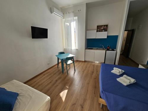 a room with a bed and a table and a kitchen at Luna Rossa in Ladispoli