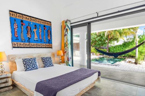 a bedroom with a bed and a hammock at Vayu - Eco Chic House Tamarin in Tamarin