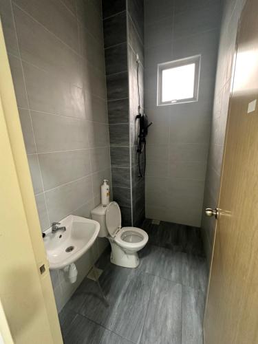 a bathroom with a toilet and a sink at Xiang Homestay in Padang Serai