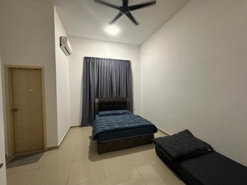 a bedroom with two beds and a ceiling fan at Xiang Homestay in Padang Serai