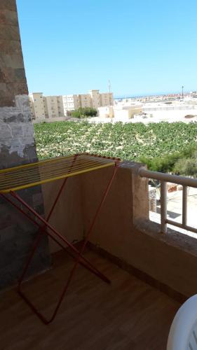a table on a balcony with a view of a field at شاليه بقرية تاهيتي الساحل الشمالي in El Hamam