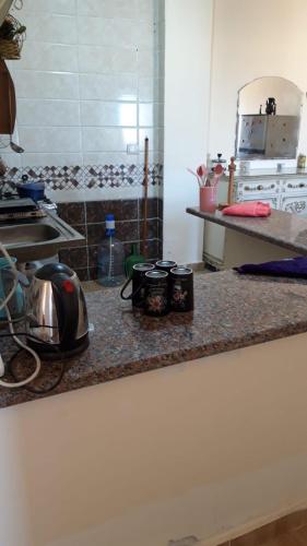 a kitchen counter with pots and pans on it at شاليه بقرية تاهيتي الساحل الشمالي in El Hamam