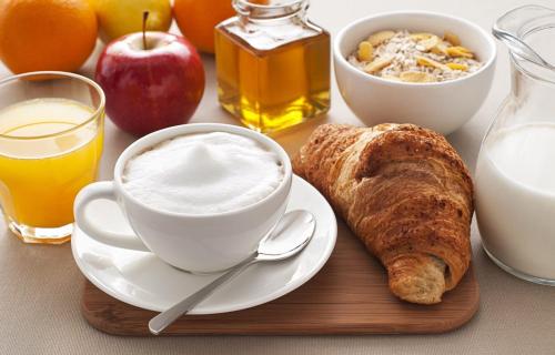 a table with a cup of coffee and a plate of food at La porta sul Duomo in Barletta