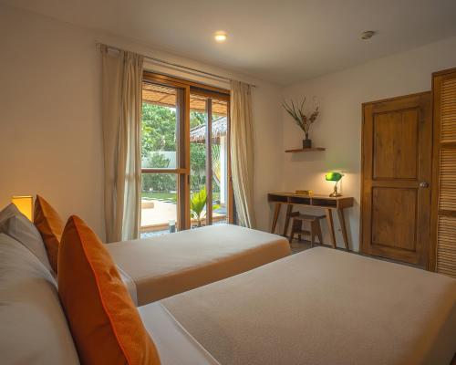 a bedroom with two beds and a table with a desk at Halamanan Residences in Panglao
