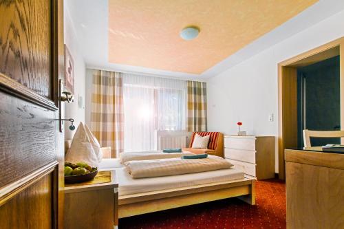 a hotel room with a bed and a window at Naturpension Mühlhof in Neukirchen am Großvenediger