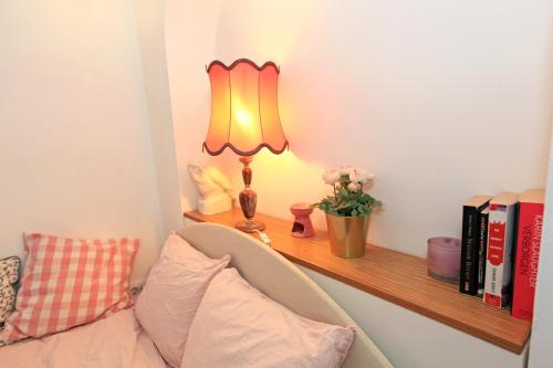 a lamp sitting on a shelf next to a couch at Cute apartment in the Ljubljana old town in Ljubljana