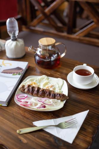 een tafel met een bord eten en een kopje koffie bij Pattaya SPA in Dubun