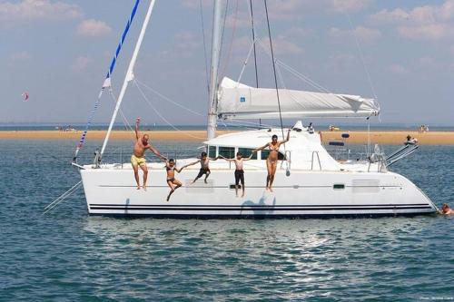 a group of people jumping off of a sailboat at StellaSmeralda in Sole Ruiu
