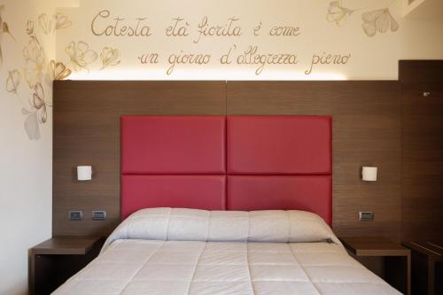 a bed with a red headboard in a bedroom at Hotel Ristorante Da Tonino in Recanati