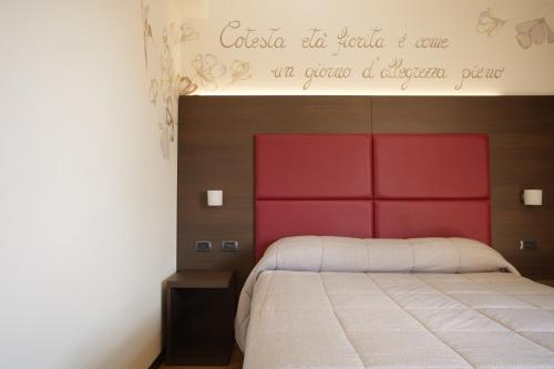 a bedroom with a bed with a red headboard at Hotel Ristorante Da Tonino in Recanati