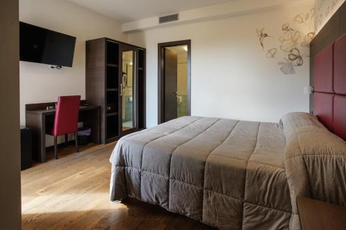 a bedroom with a bed and a desk and a computer at Hotel Ristorante Da Tonino in Recanati