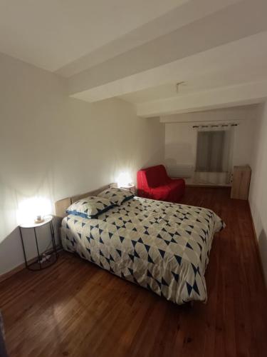 a bedroom with a bed and a red chair at La terrasse des Augustins in Limoux