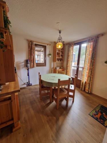 une salle à manger avec une table et des chaises et une fenêtre dans l'établissement Appartement Cosy, à Risoul