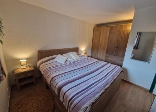 - une chambre avec un grand lit et 2 lampes dans l'établissement Appartement Cosy, à Risoul