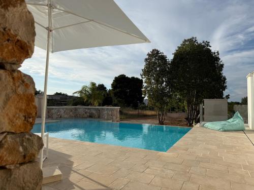 a white umbrella sitting next to a swimming pool at Abate Filippo apartment in Nardò